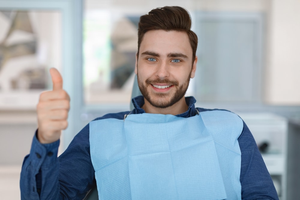 Cheerful,Bearded,Man,Patient,Sitting,In,Dental,Chair,And,Smiling
