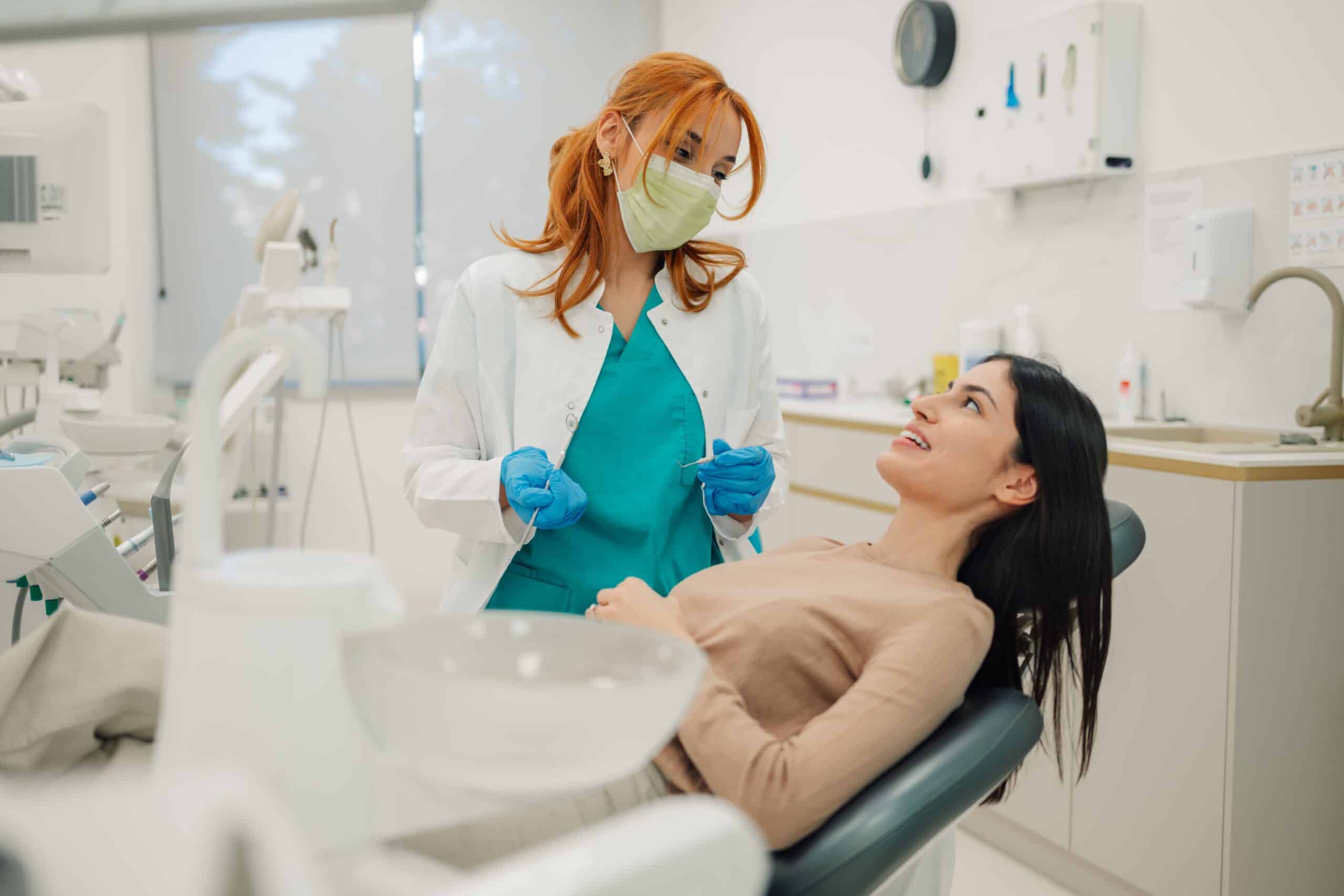 Female,Dentist,Wearing,Surgical,Mask,And,Gloves,Holding,Dental,Tools