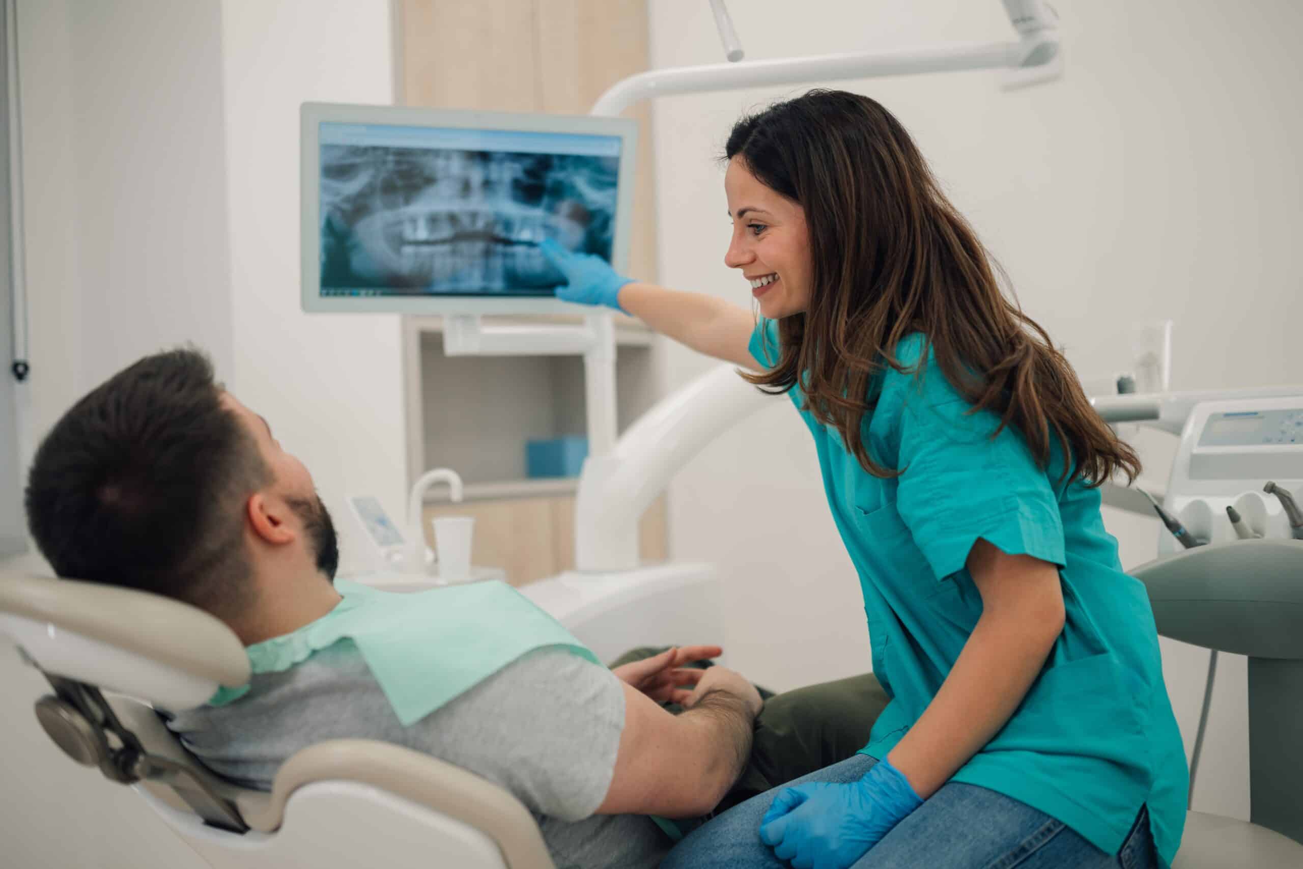 Female,Dentist,Pointing,At,A,Digital,X,Ray,On,A