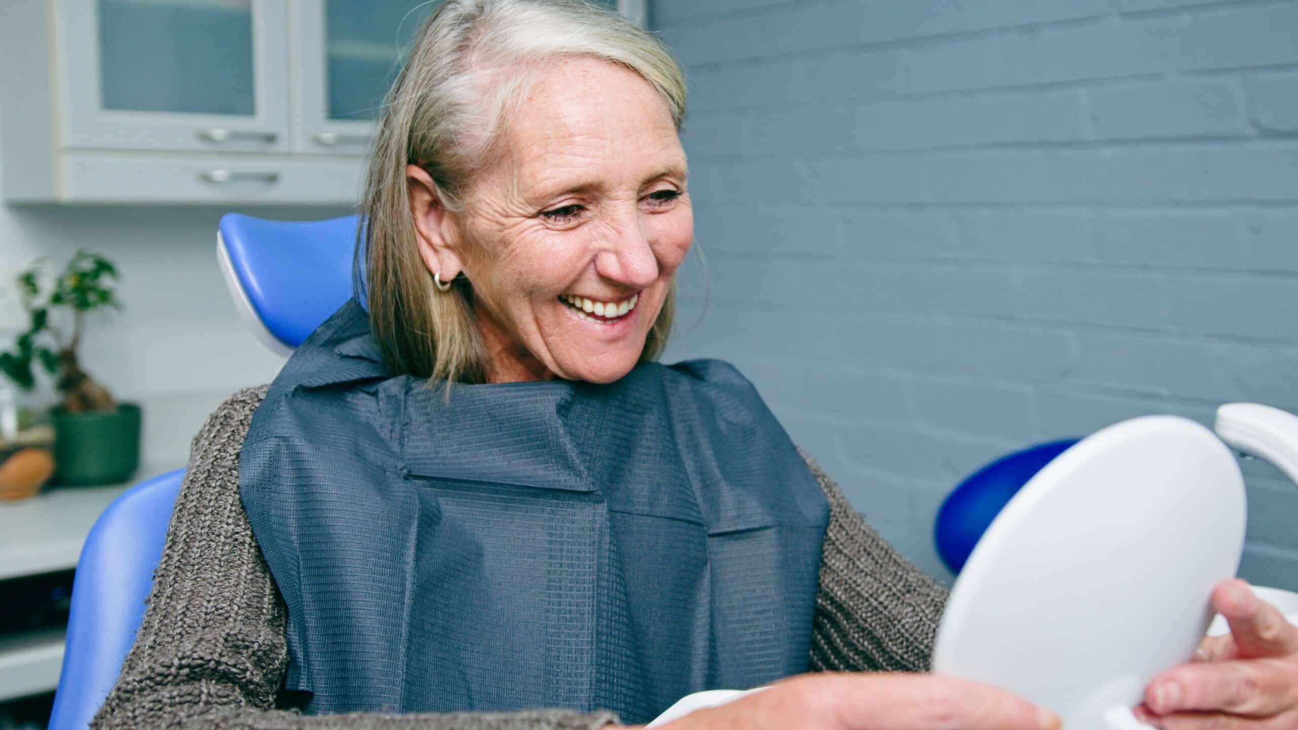 Mature,Woman,Smiling,At,Dental,Clinic,While,Checking,Teeth,In