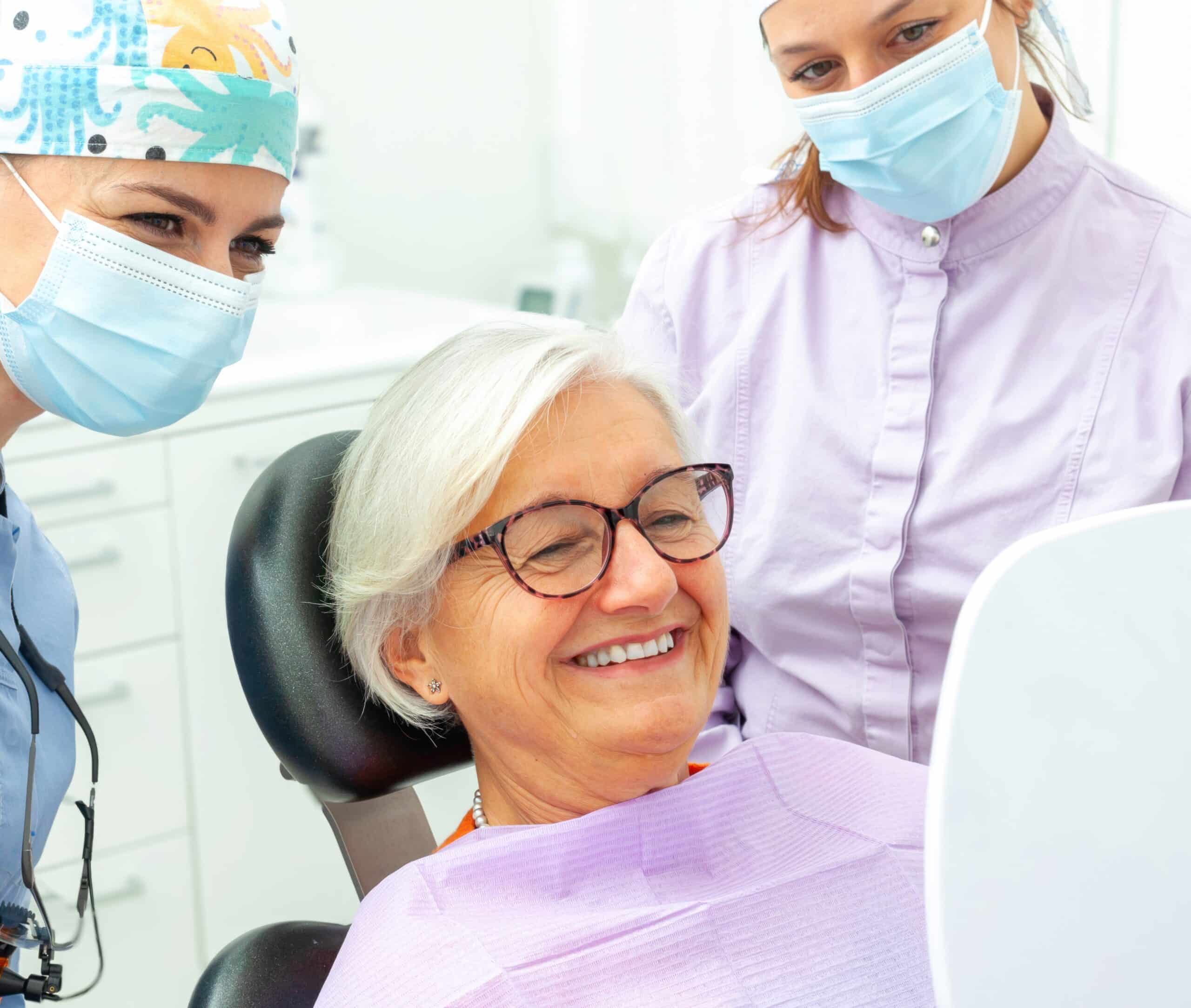 Dentists,Assisting,A,Senior,Woman,As,She,Admires,Her,Smile