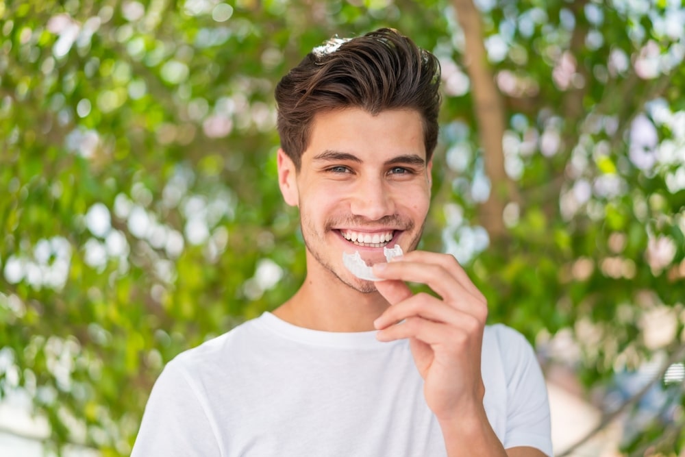Young,Caucasian,Man,At,Outdoors,Holding,Invisible,Braces