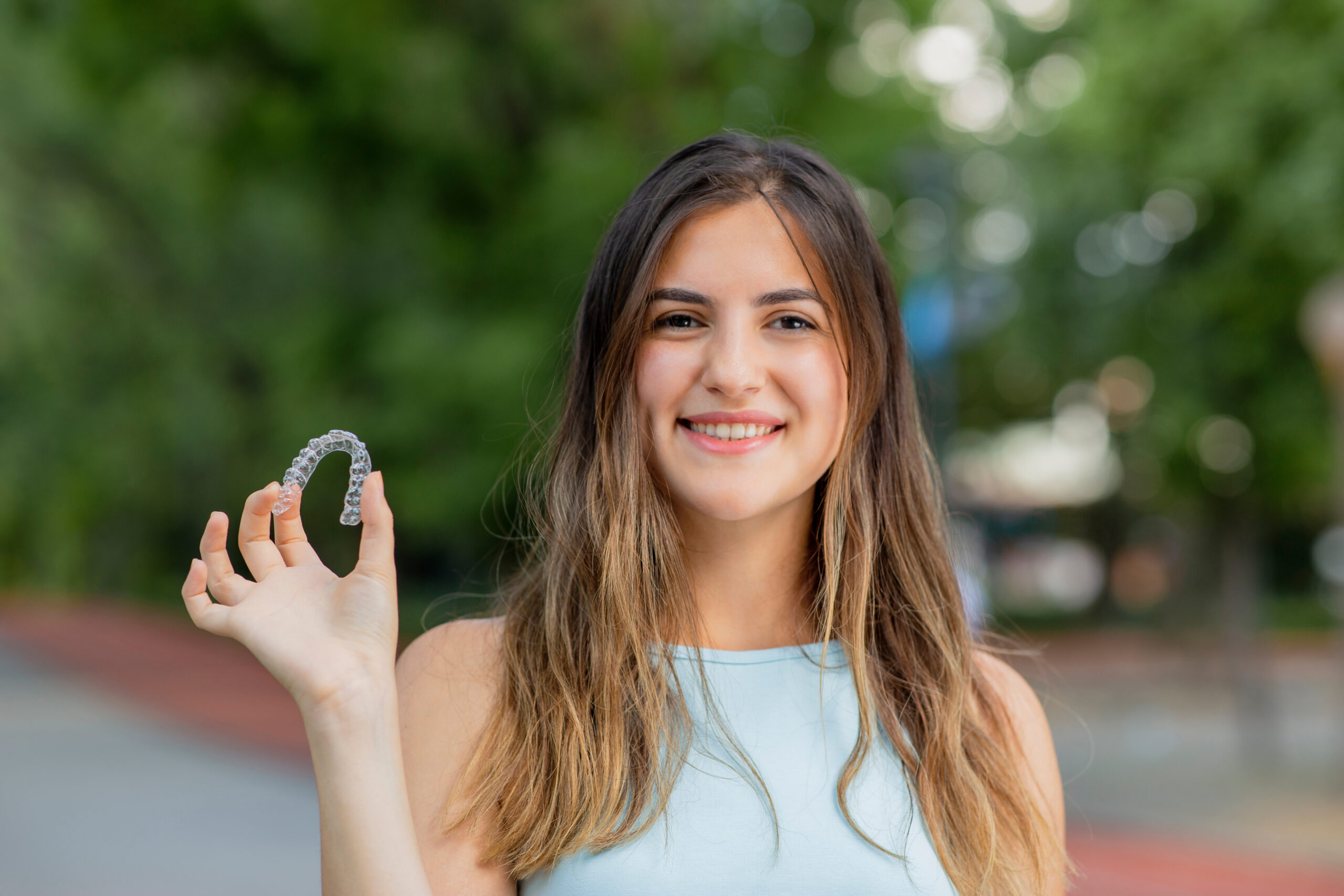 Beautiful,Smiling,Turkish,Woman,Is,Holding,An,Invisalign,Bracer
